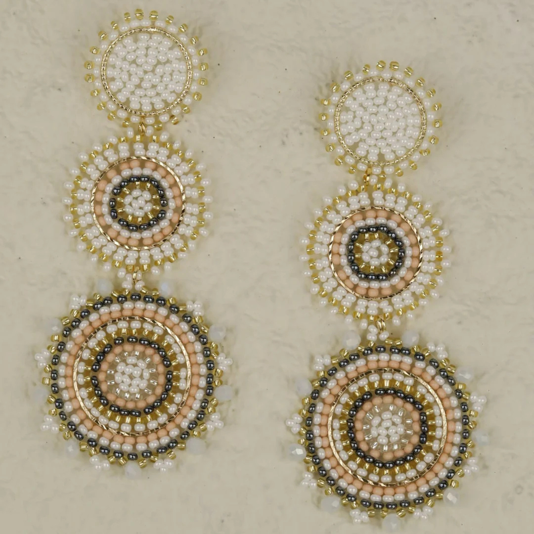 Beaded earrings with circular design on a beige background