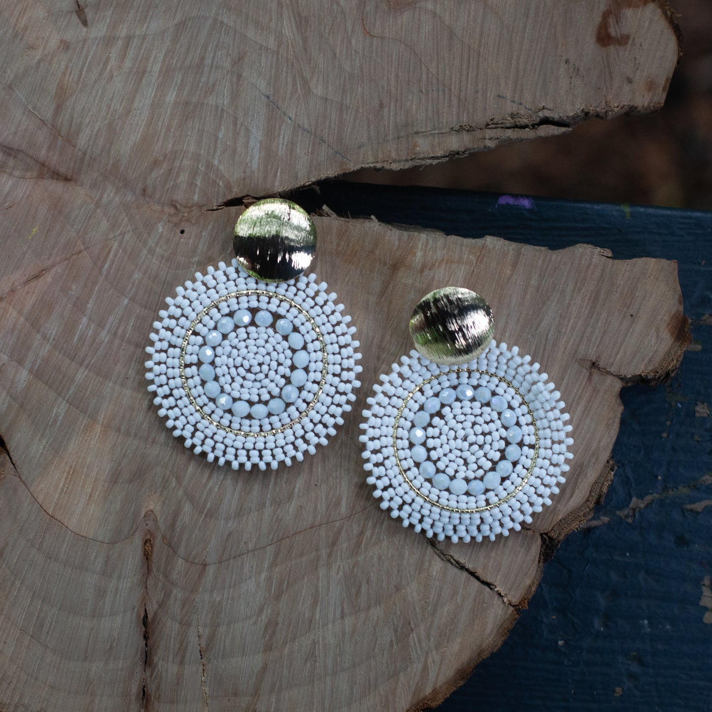 These earrings are handcrafted with colorful beadwork on a delicate wire and feature a bronze stud with a gleaming gold plating, available in a variety of colors.