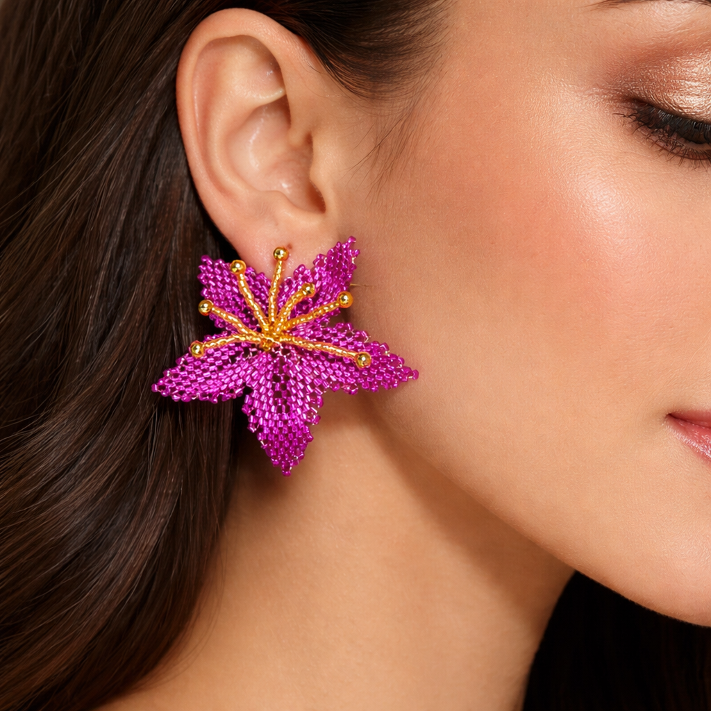 Close-up of a woman wearing a vibrant pink and gold floral earring.