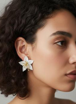 Woman wearing a floral earring against a neutral background