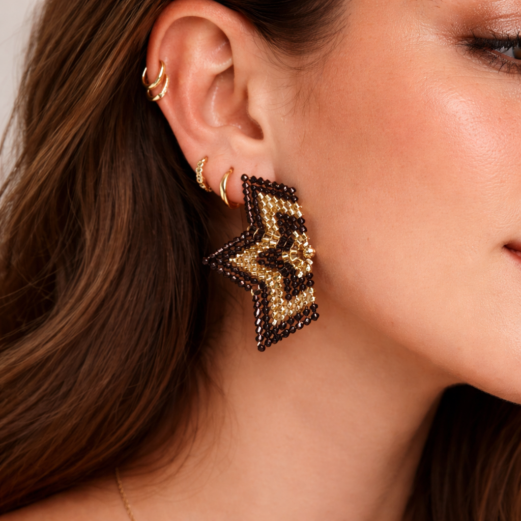 Close-up of a woman wearing gold and black beaded earrings.