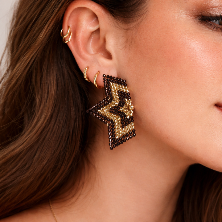 Close-up of a woman wearing gold and black beaded earrings.