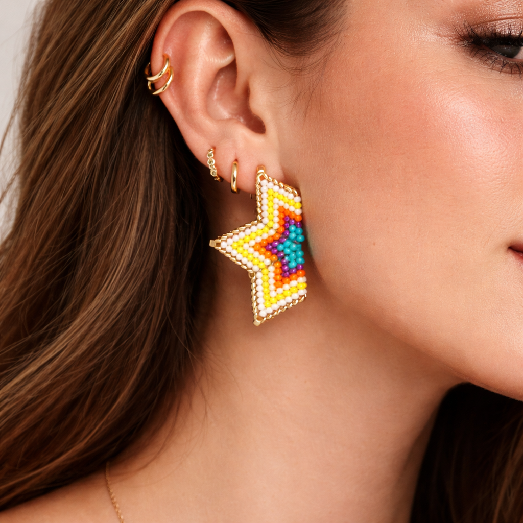 Close-up of a woman wearing colorful star-shaped earrings with gold ear cuffs.