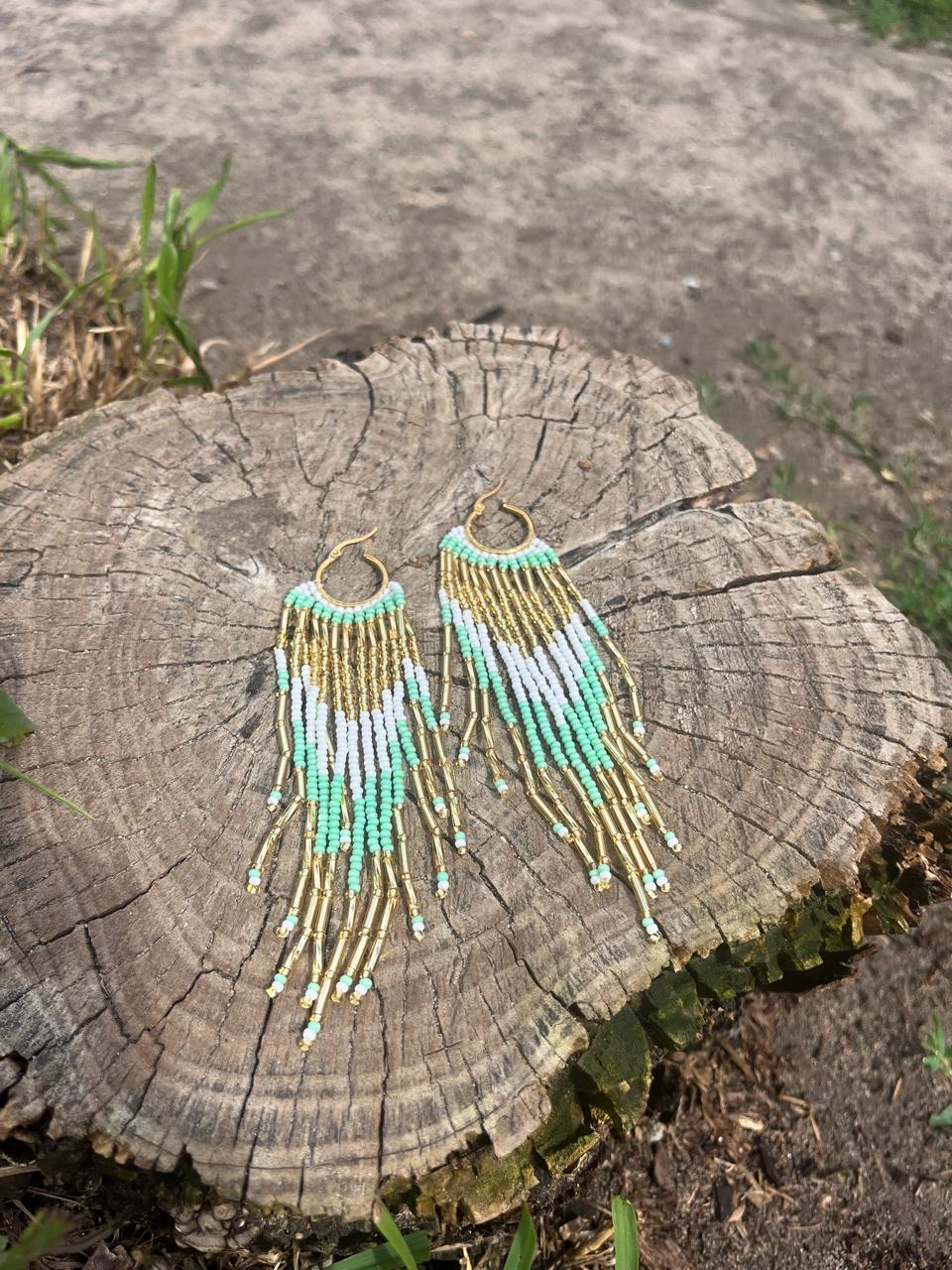 Dangling earrings handmade with beads on wire, featuring a bronze stud with gold plating, available in various colors. Handmade with the highest quality materials, these earrings are truly unique. Each pair features a variety of colors to match any outfit and every occasion.
