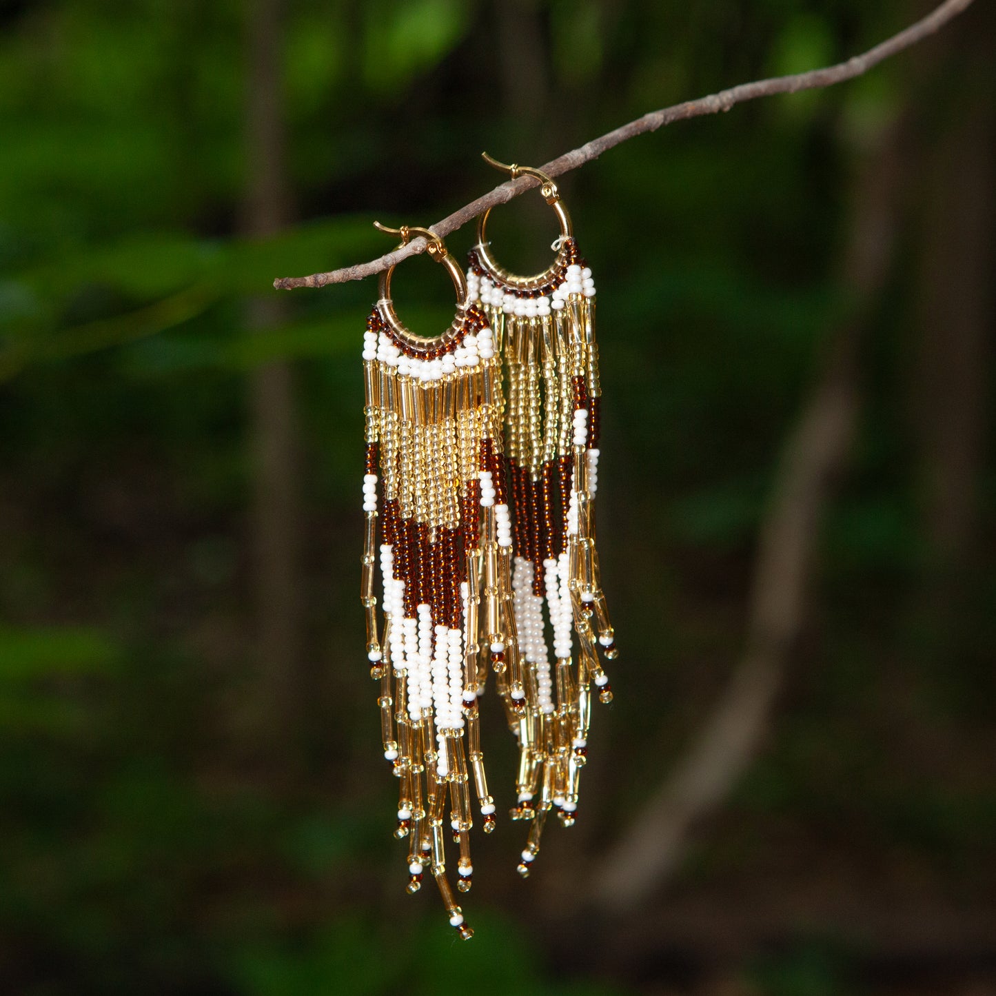 Dangling earrings handmade with beads on wire, featuring a bronze stud with gold plating, available in various colors. Handmade with the highest quality materials, these earrings are truly unique. Each pair features a variety of colors to match any outfit and every occasion.